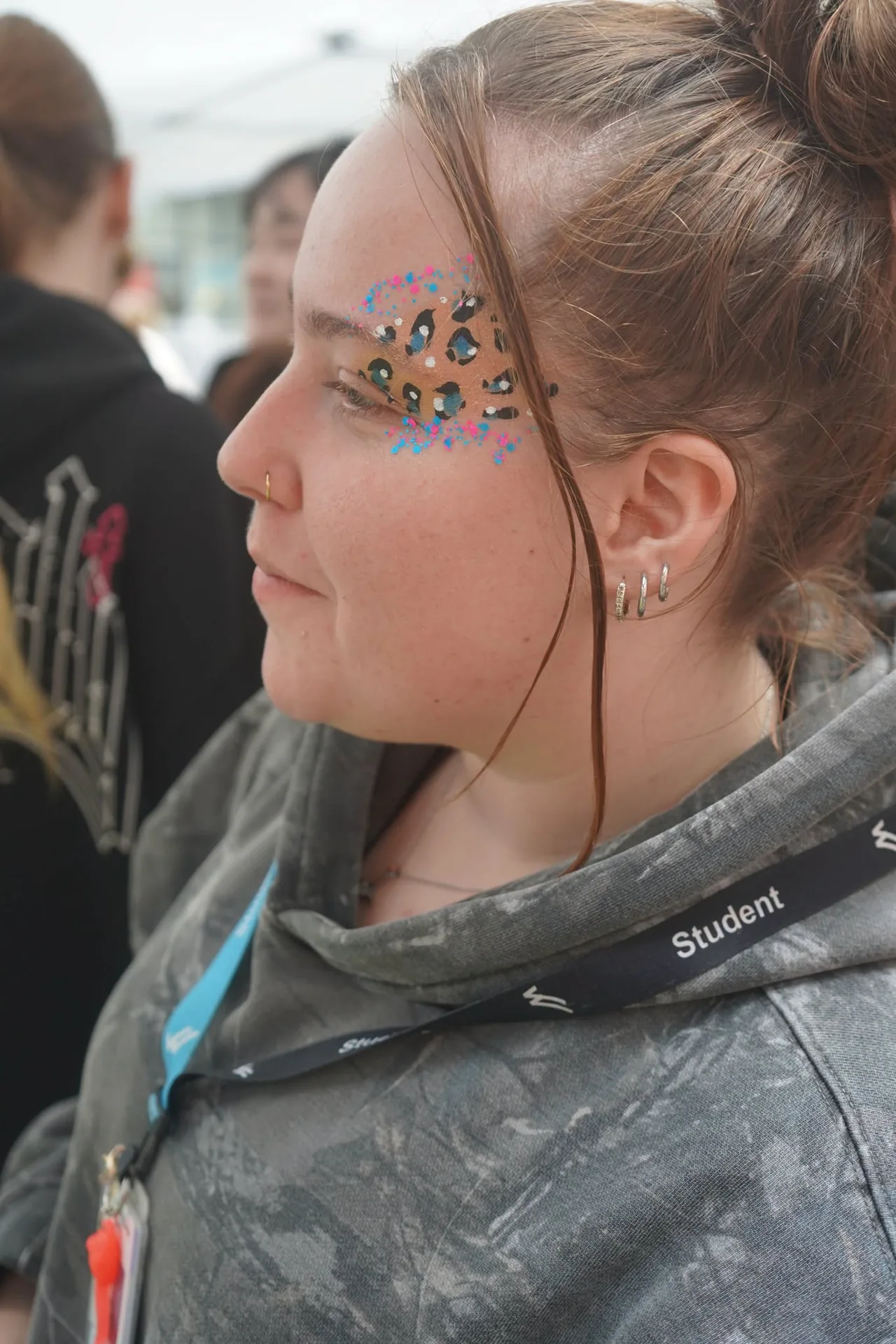 Close-up of a colourful spotted face painting design around an attendee’s eye