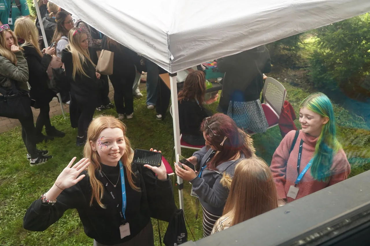 Attendees gathered beside an outdoor canopy at the college’s Enrichment Fayres