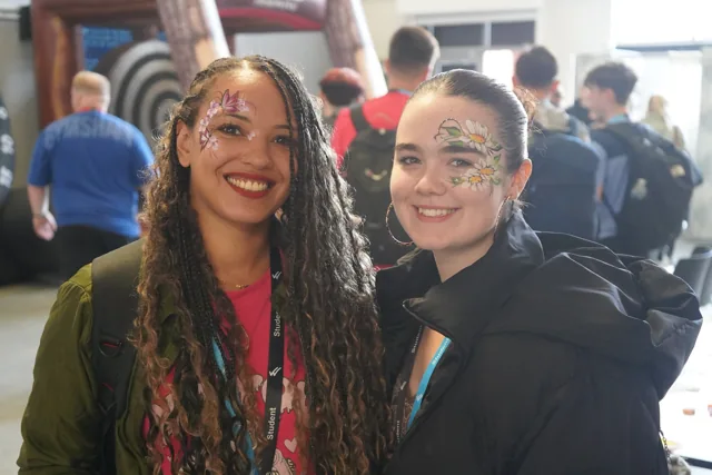 Two attendees with colourful face painting at Wigan & Leigh College’s Enrichment Fayres