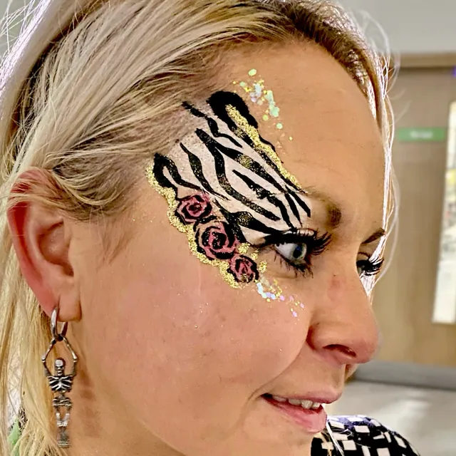 Black and white striped eye design with pink roses and gold glitter