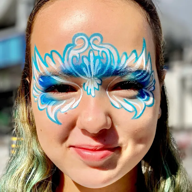 Blue and white masquerade-style face painting around both eyes