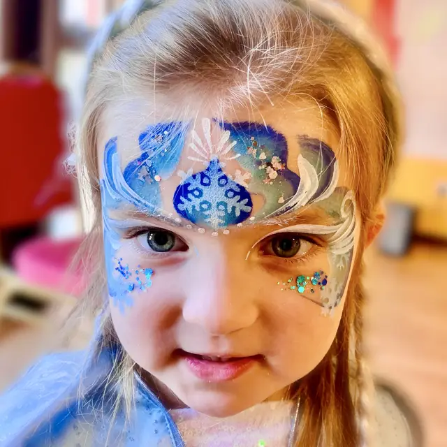 Blue and gold ice-princess face painting with snowflakes